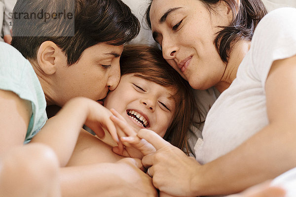 Kaukasische Familie kuschelnd im Bett