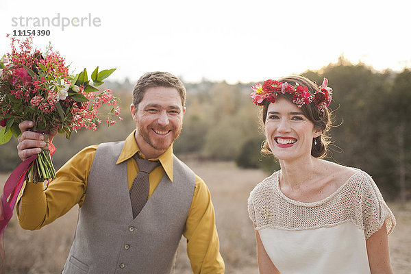 Braut und Bräutigam lächelnd in einem ländlichen Feld