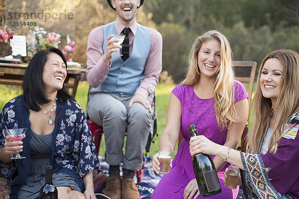 Freunde trinken Champagner beim Picknick im Park