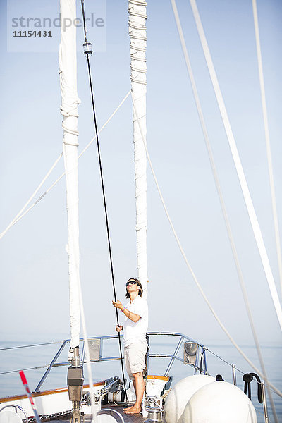 Kaukasische Frau auf dem Deck eines Segelboots stehend