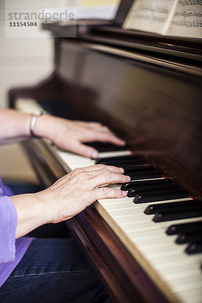 Nahaufnahme einer kaukasischen Musikerin beim Klavierspielen