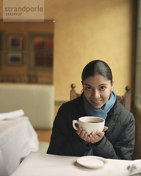 Indische Frau trinkt Kaffee in einem Cafe