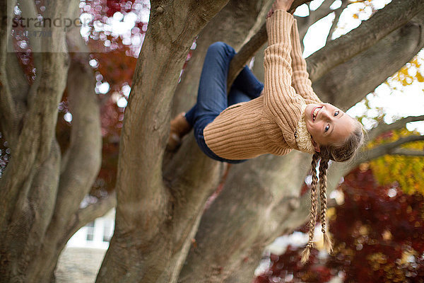Niedriger Winkel Blick auf lächelnde Mädchen kletternden Baum