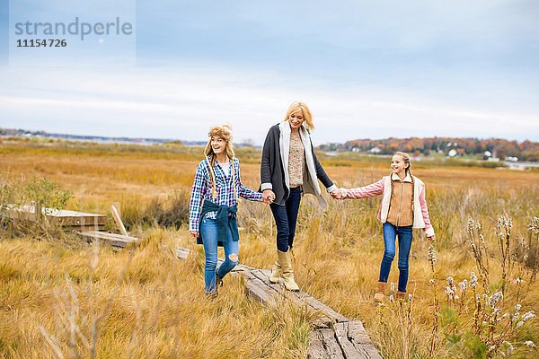 Mutter und Töchter spazieren auf einem ländlichen Feld