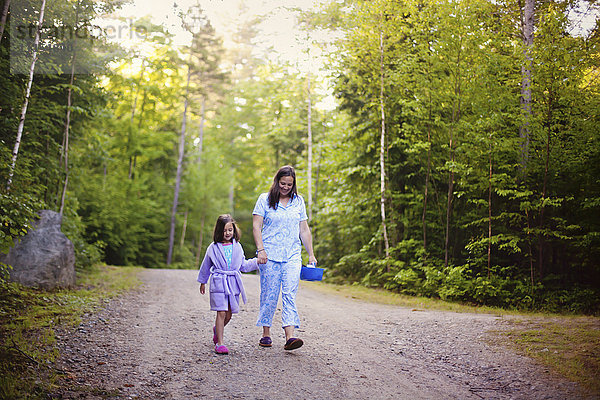 Kaukasische Mutter und Tochter gehen auf einem Feldweg