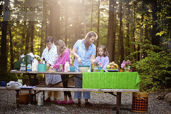 Drei Generationen von kaukasischen Frauen kochen am Picknicktisch