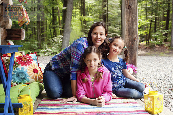 Kaukasische Mutter und Töchter lächelnd auf Veranda