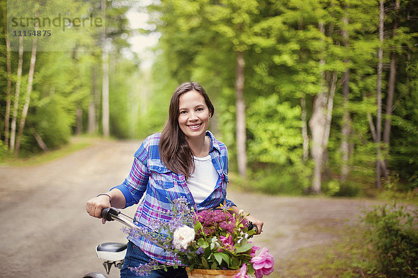 Kaukasische Frau mit Fahrrad auf unbefestigtem Weg