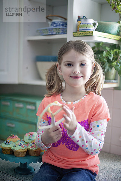Kaukasisches Mädchen leckt Mischpult in der Küche
