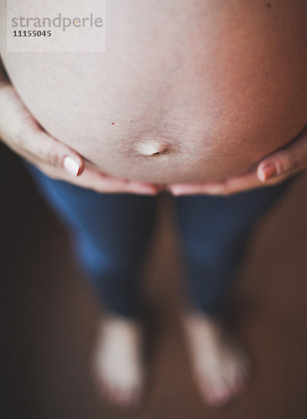 Nahaufnahme des Bauches einer schwangeren kaukasischen Frau