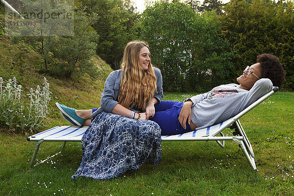 Teenager-Mädchen entspannen sich auf einem Liegestuhl