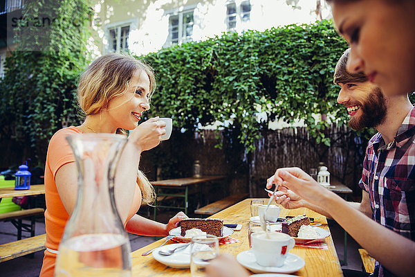 Freunde im Freien bei Kaffee und Kuchen