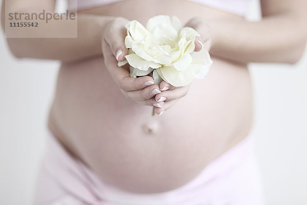 Schwangere kaukasische Frau mit Blume