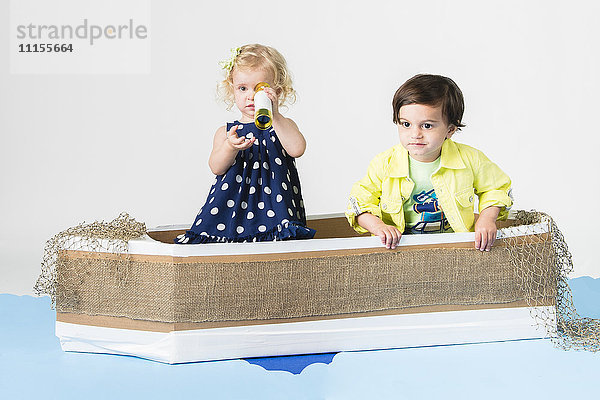 Kinder spielen im Pappboot