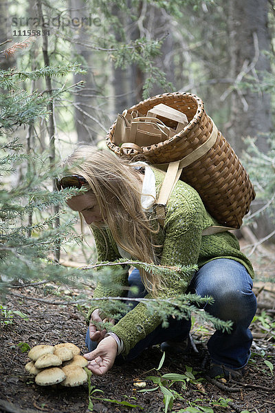 Frau auf Pilzsuche im Wald