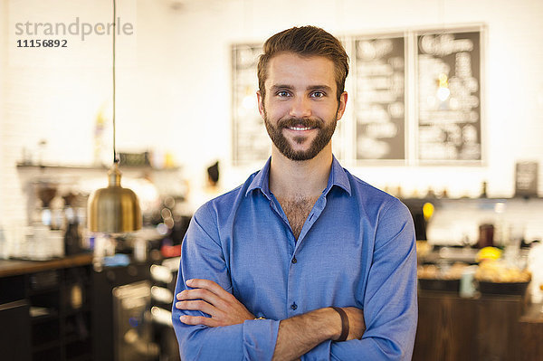Porträt eines selbstbewussten jungen Mannes im Cafe