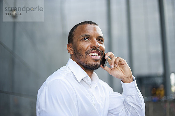 Porträt eines lächelnden Geschäftsmannes am Telefon