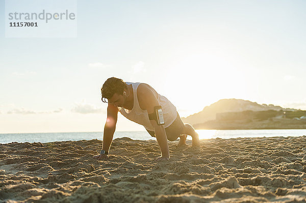 Spanien  Mallorca  Jogger am Strand bei Sonnenaufgang  Liegestütze