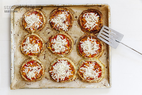 Hausgemachte glutenfreie Mini-Pizzen mit Blumenkohl und Kürbis auf Backblech
