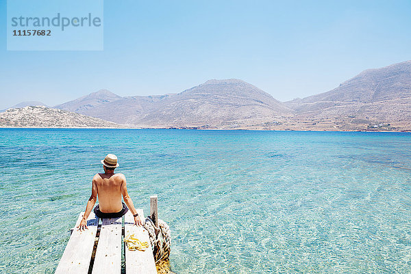 Griechenland  Kykladen  Amorgos  Mann am Rande eines hölzernen Piers  Insel Nikouria