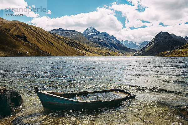 Peru  Huaraz  Holzboot versenkt in einer Lagune mit Cordillera Blanca Bergen im Hintergrund