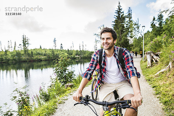 Junger Mann auf dem Fahrrad in der Natur