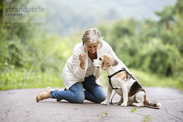 Seniorin mit ihrem Hund in der Natur