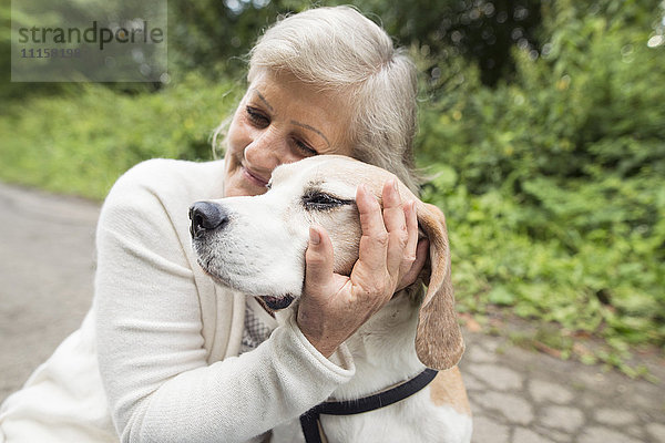 Glückliche Seniorin beim Kuscheln ihres Hundes