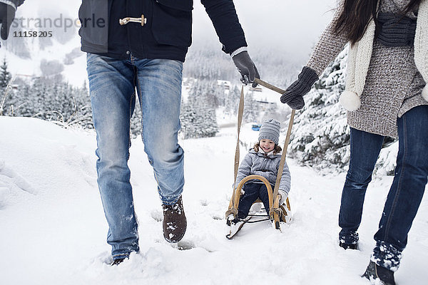 Familie mit Schlitten in der Winterlandschaft