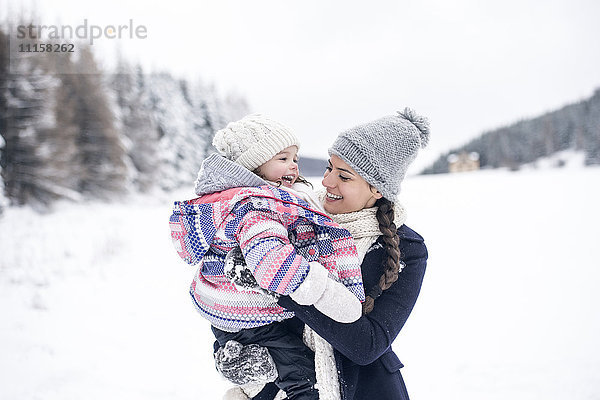 Glückliche Mutter mit Tochter in Winterlandschaft