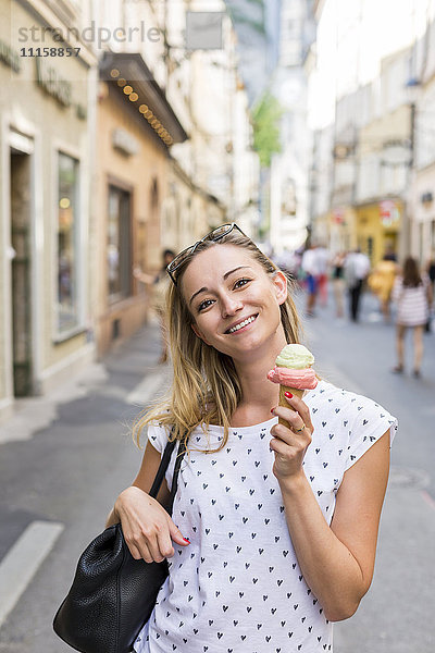Österreich  Salzburg  lächelnde Frau auf der Einkaufsstraße mit Eistüte