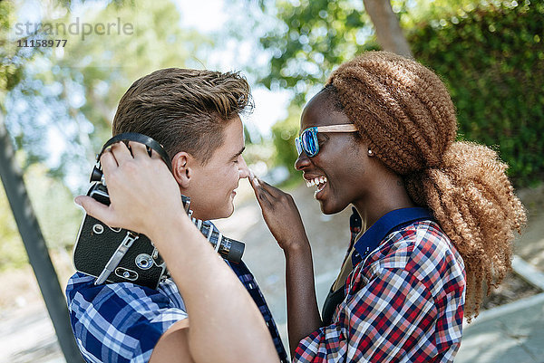 Glückliches junges Paar mit einer altmodischen Kamera im Freien