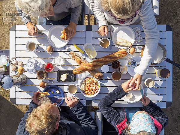 Familie auf dem Tisch sitzend  Frühstück