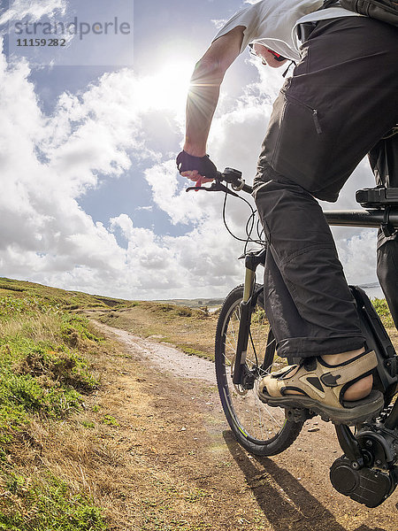 Frankreich  Bretagne  Senior auf elektrischem Mountainbike auf dem Küstenweg