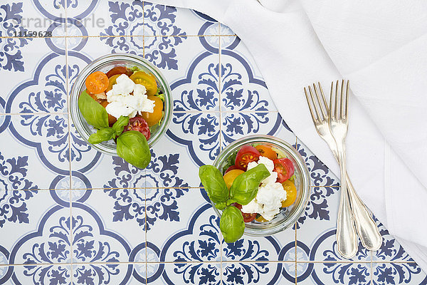 Teo Gläser Blattsalat mit Ziegenfrischkäse und Tomaten auf Fliesen