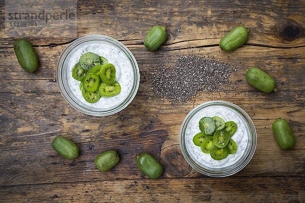Zwei Gläser Naturjoghurt mit Chiasamen und Kiwischeiben