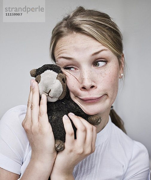 Junge Frau macht ein lustiges Gesicht mit Kuscheltierchen