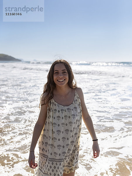 Porträt einer lächelnden jungen Frau am Meer