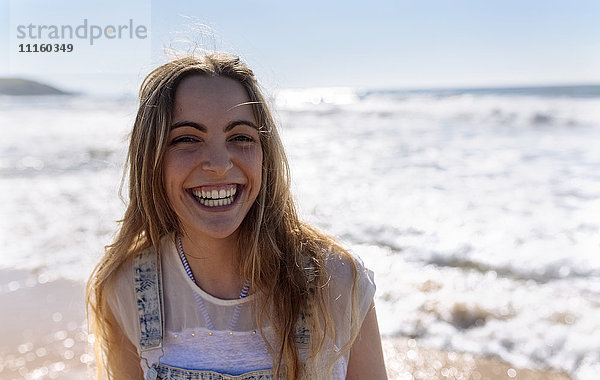 Porträt eines lachenden Teenagermädchens am Strand