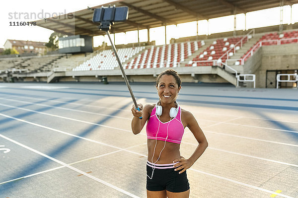 Sportlerin  die sich im Stadion selbstständig macht  mit einem Selfie-Stick.
