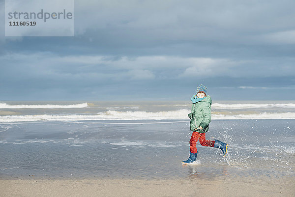 Dänemark  Skagen  Junge in Winterkleidung am Strand unterwegs