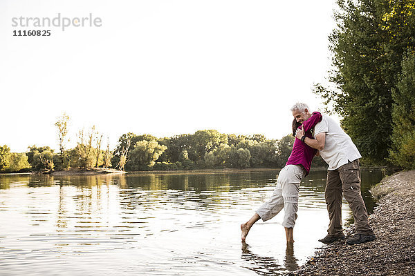 Seniorenpaar beim Umarmen am See