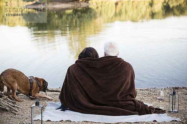 Entspanntes Seniorenpaar mit Hund am See