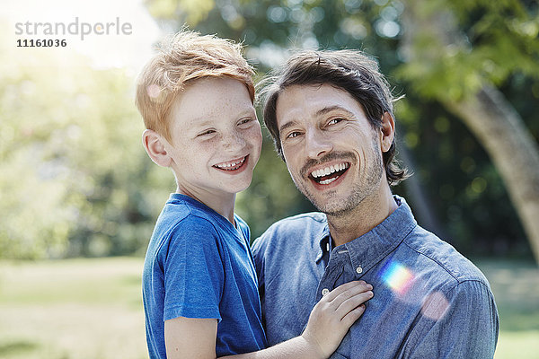 Porträt eines glücklichen Vaters mit Sohn im Garten