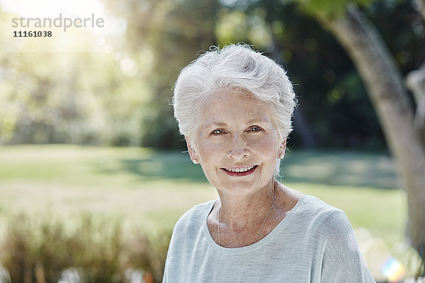 Porträt einer lächelnden Seniorin im Park