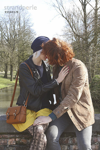 Junges Paar  das sich auf einer Brücke küsst