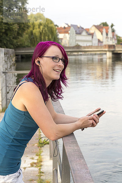 Lächelnde Frau mit gefärbten Haaren Musik hören mit Kopfhörern