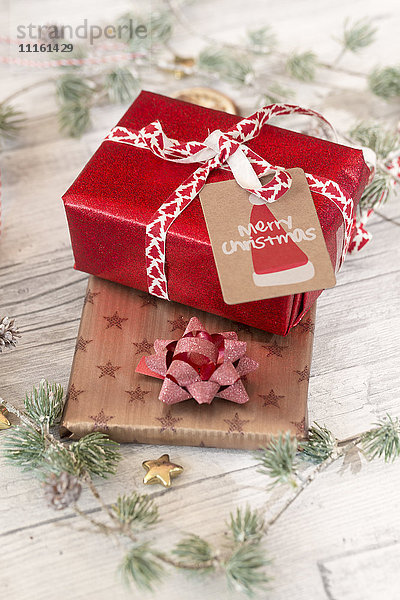 Weihnachtsdekoration und verpackte Geschenke auf Holz
