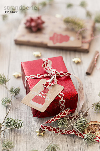 Weihnachtsdekoration und verpackte Geschenke auf Holz