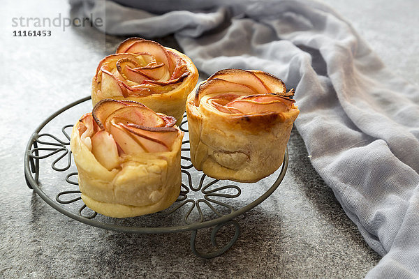 Filo pastry apple cakes in rose shape on cooling grid